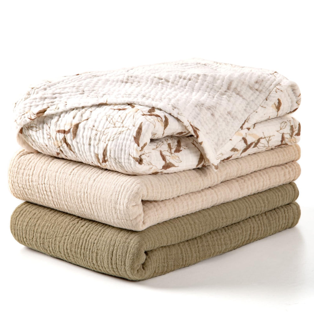 lulumoon muslin swaddle olive branches blanket close-up showing soft cotton texture for newborn comfort.