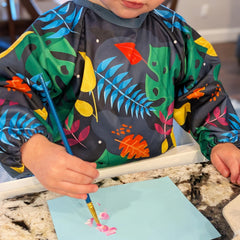 Madrona Brands toddler smock worn by child during arts and crafts.