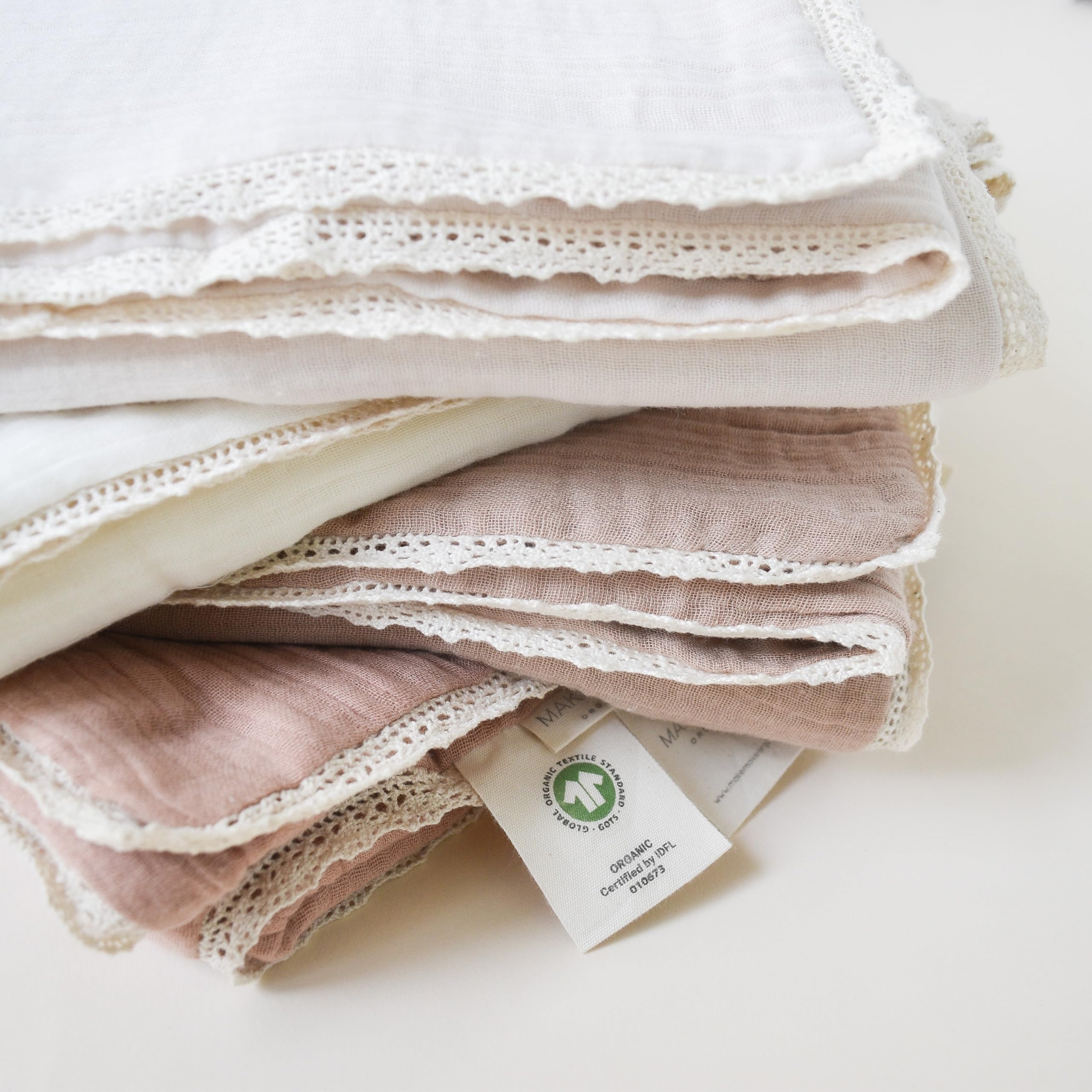 MakeMake Organics muslin blanket being used as a newborn swaddle for snug comfort.