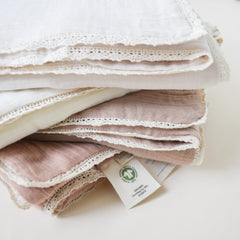 MakeMake Organics muslin blanket being used as a newborn swaddle for snug comfort.