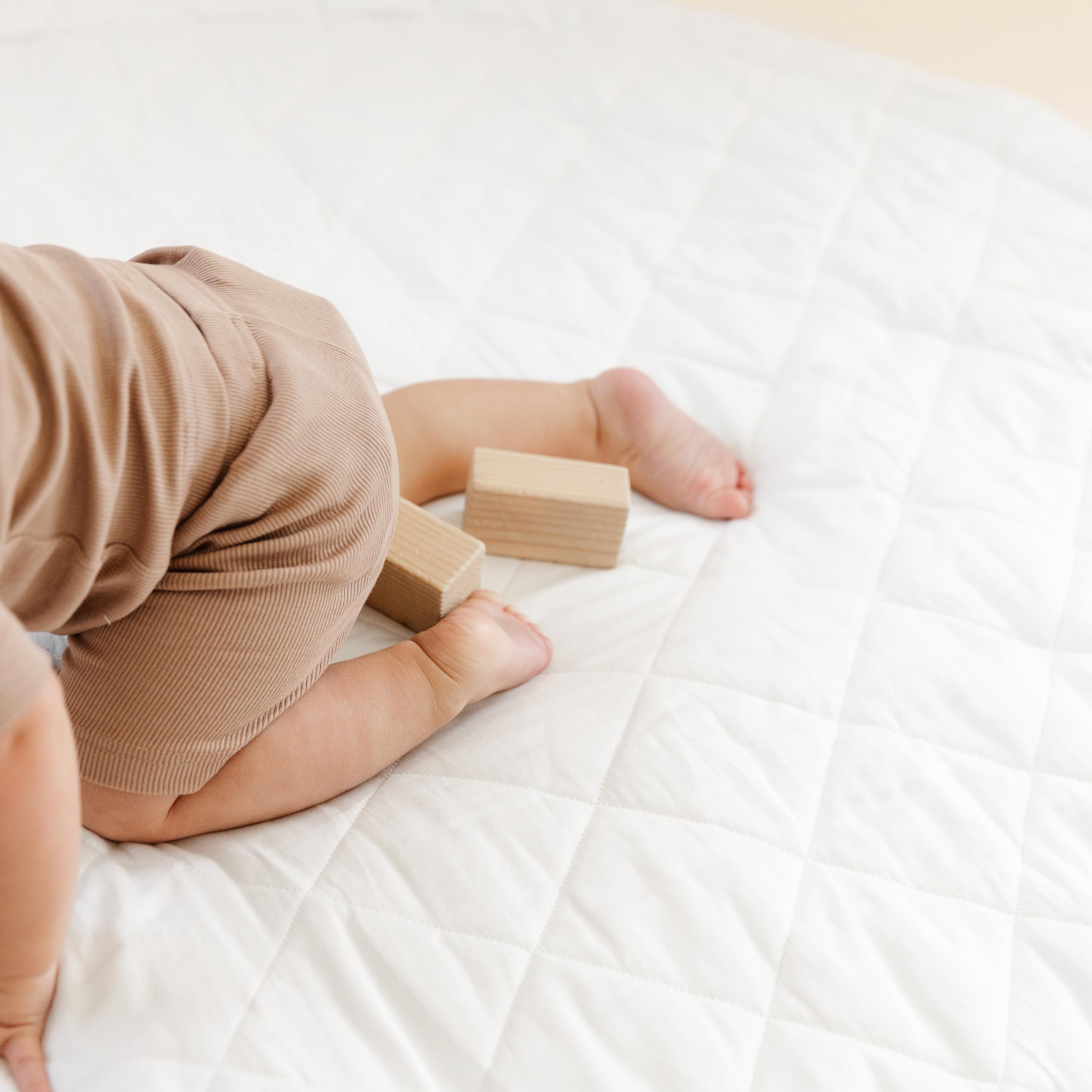 MakeMake Organics Thick quilted padding supports comfortable crawling and growth.
