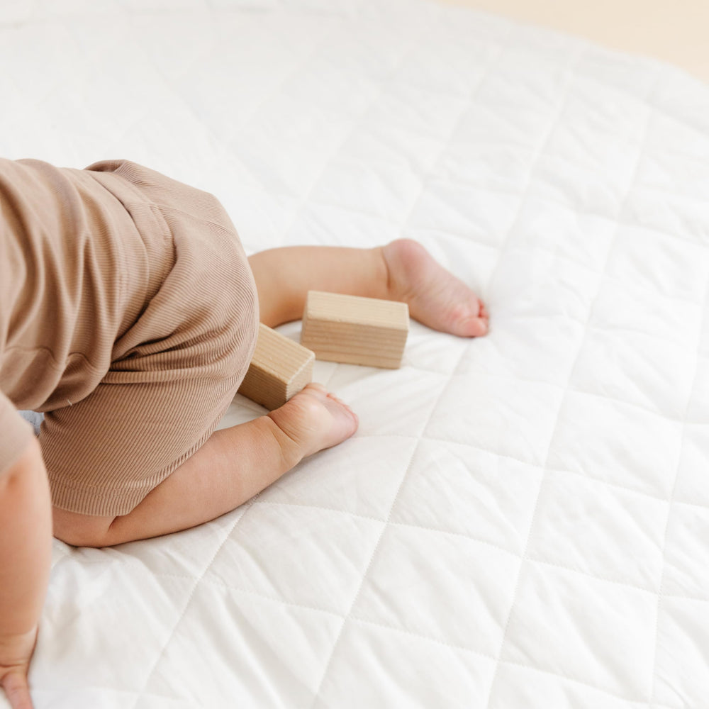 MakeMake Organics Thick quilted padding supports comfortable crawling and growth.