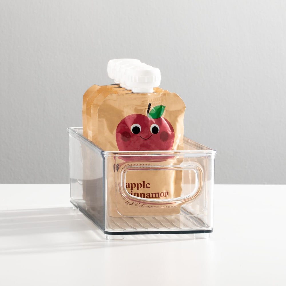 MDesign stackable clear nursery bin demonstrates versatile storage for bottles and cups.