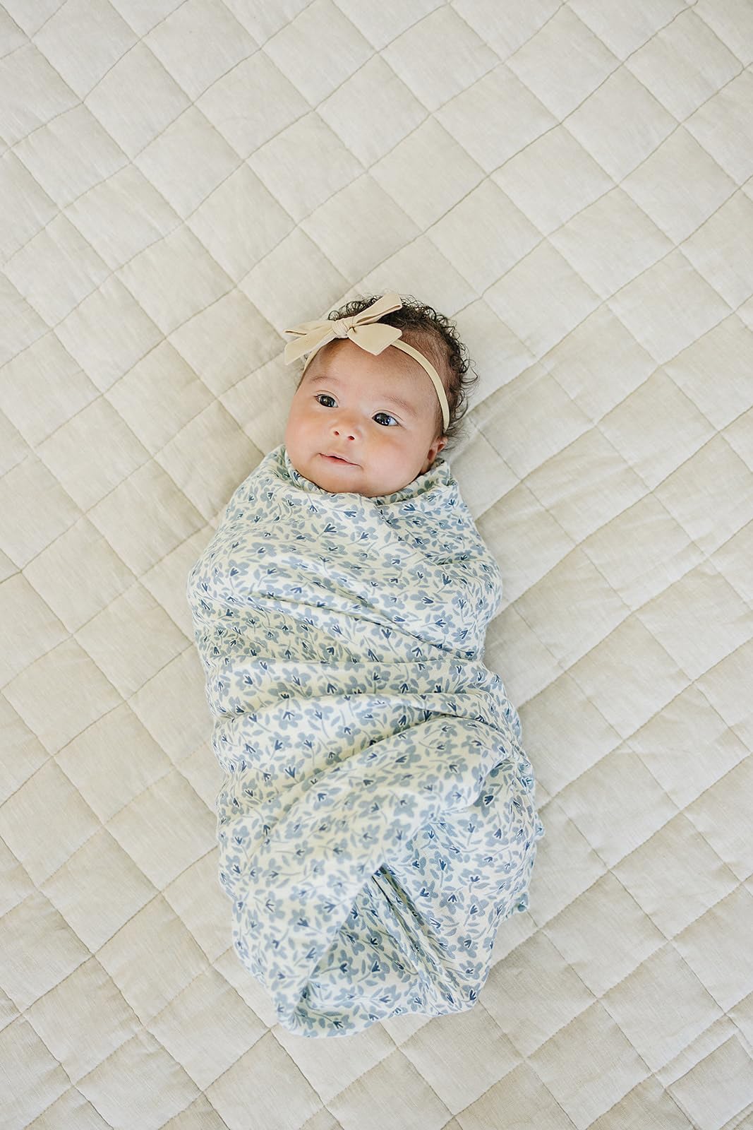 Mebie Baby Blue Blossom swaddle wrapped around baby for secure, cozy sleep