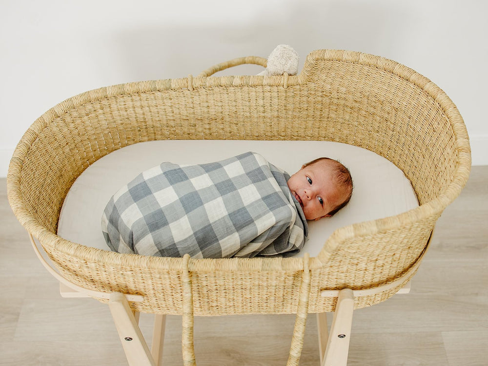 Mebie Baby Dusty Blue Gingham Swaddle used as a lightweight blanket