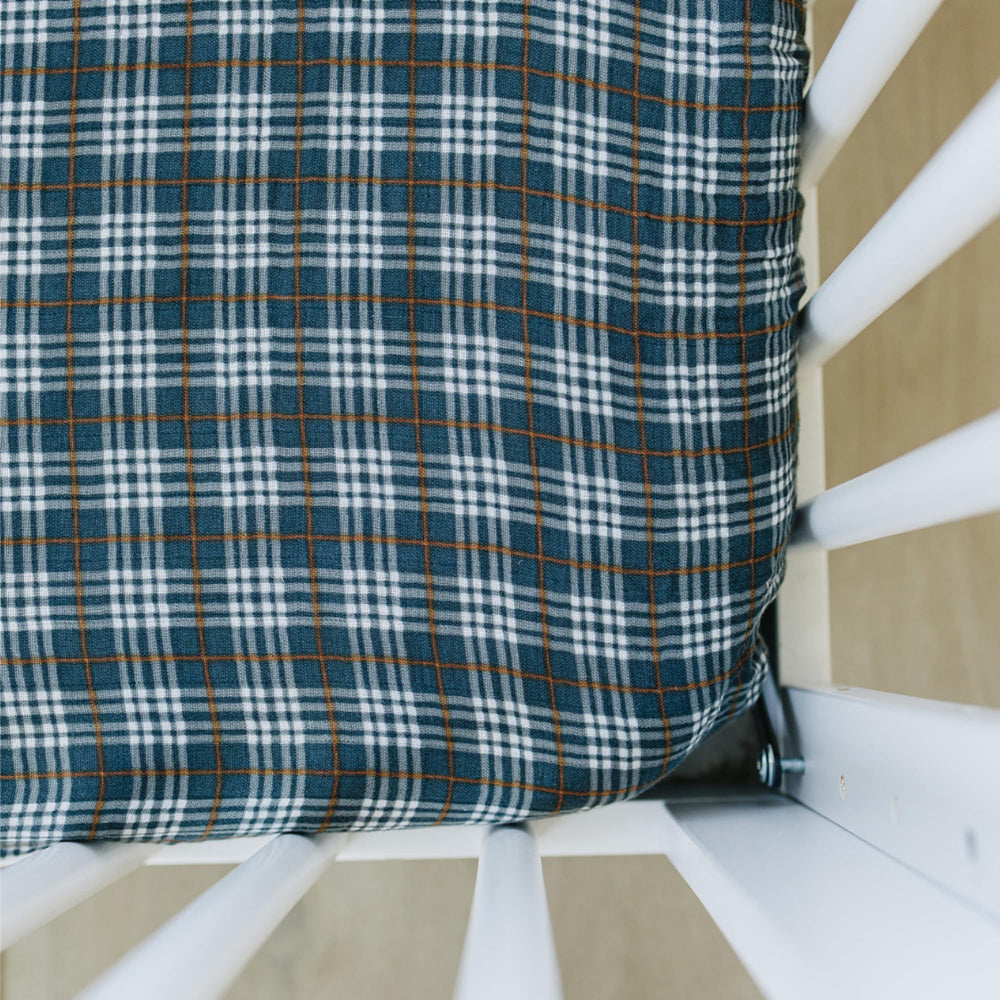 Mebie Baby navy plaid muslin sheet closeup showing soft, breathable fabric for comfy baby sleep
