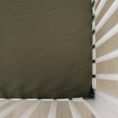 Mebie Baby stretch sheet olive on crib mattress for snug sleep fit.