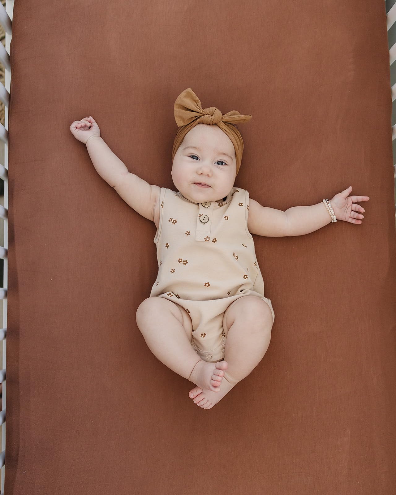 Mebie Baby stretch sheet rust folded to show compact size and color.