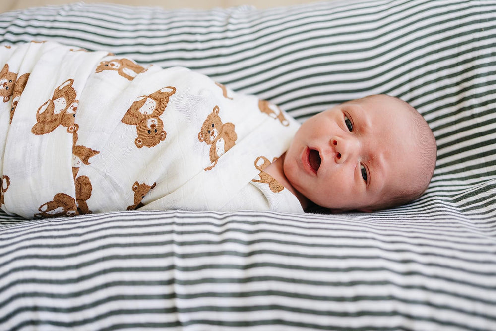 Mebie Baby Teddy Bear Muslin Swaddle in-use demonstrates versatile wrap for swaddling and lightweight blanket use.