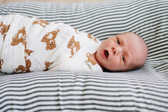 Mebie Baby Teddy Bear Muslin Swaddle in-use demonstrates versatile wrap for swaddling and lightweight blanket use.