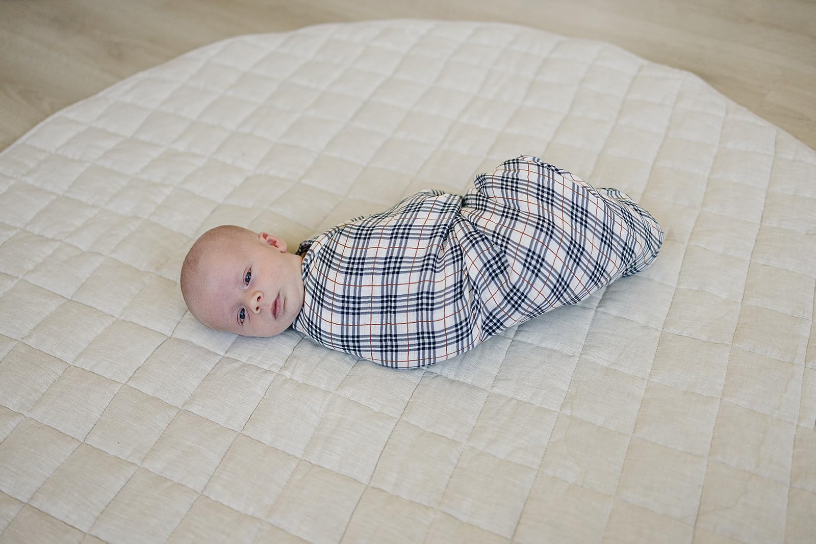 Mebie Baby plaid muslin swaddle shown in crib-ready, gender-neutral design.