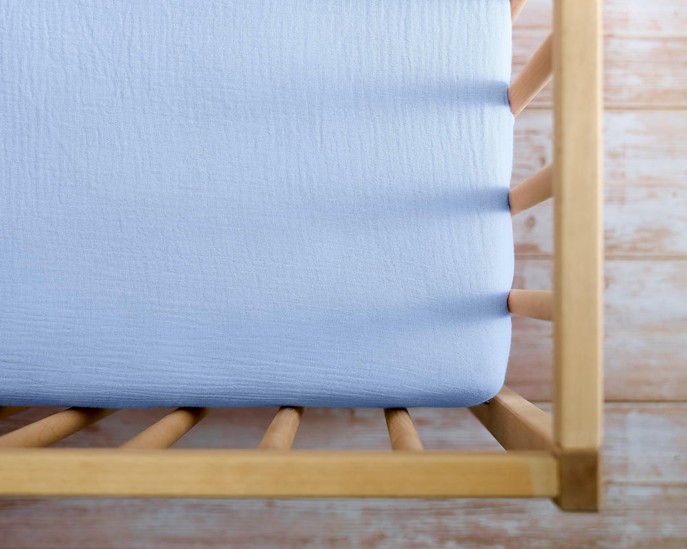 Meracorallo muslin crib sheet in a baby bedroom setup highlighting calm blue tones.