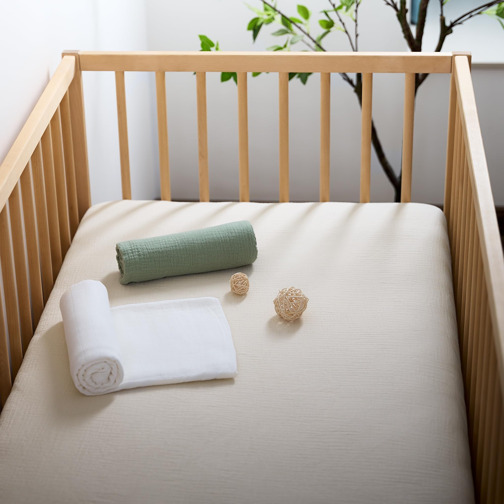 Meracorallo muslin crib sheet cream bedroom scene with baby peacefully resting