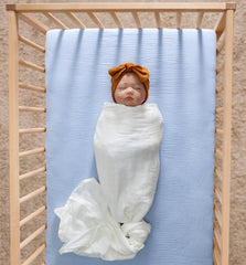 Meracorallo muslin crib sheet on mattress for a snug, secure fit.