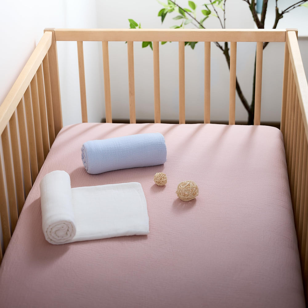 Meracorallo muslin crib sheet pink mattress fit showing snug fit.