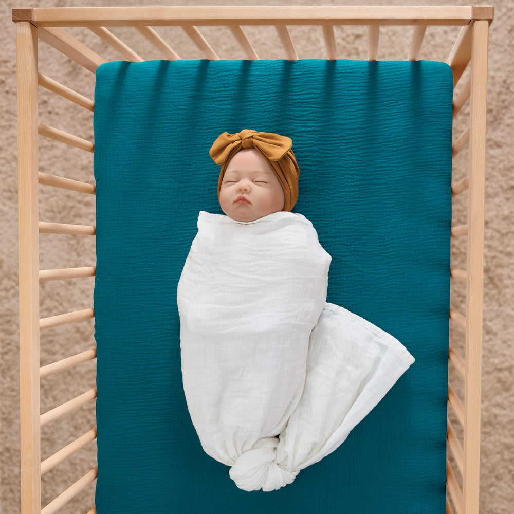 Meracorallo teal muslin crib sheet close-up showing pre-washed softness