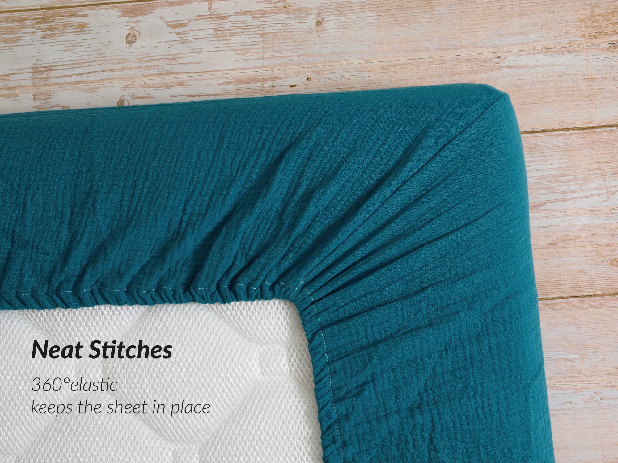 Meracorallo teal muslin sheet shown on standard crib and toddler mattress