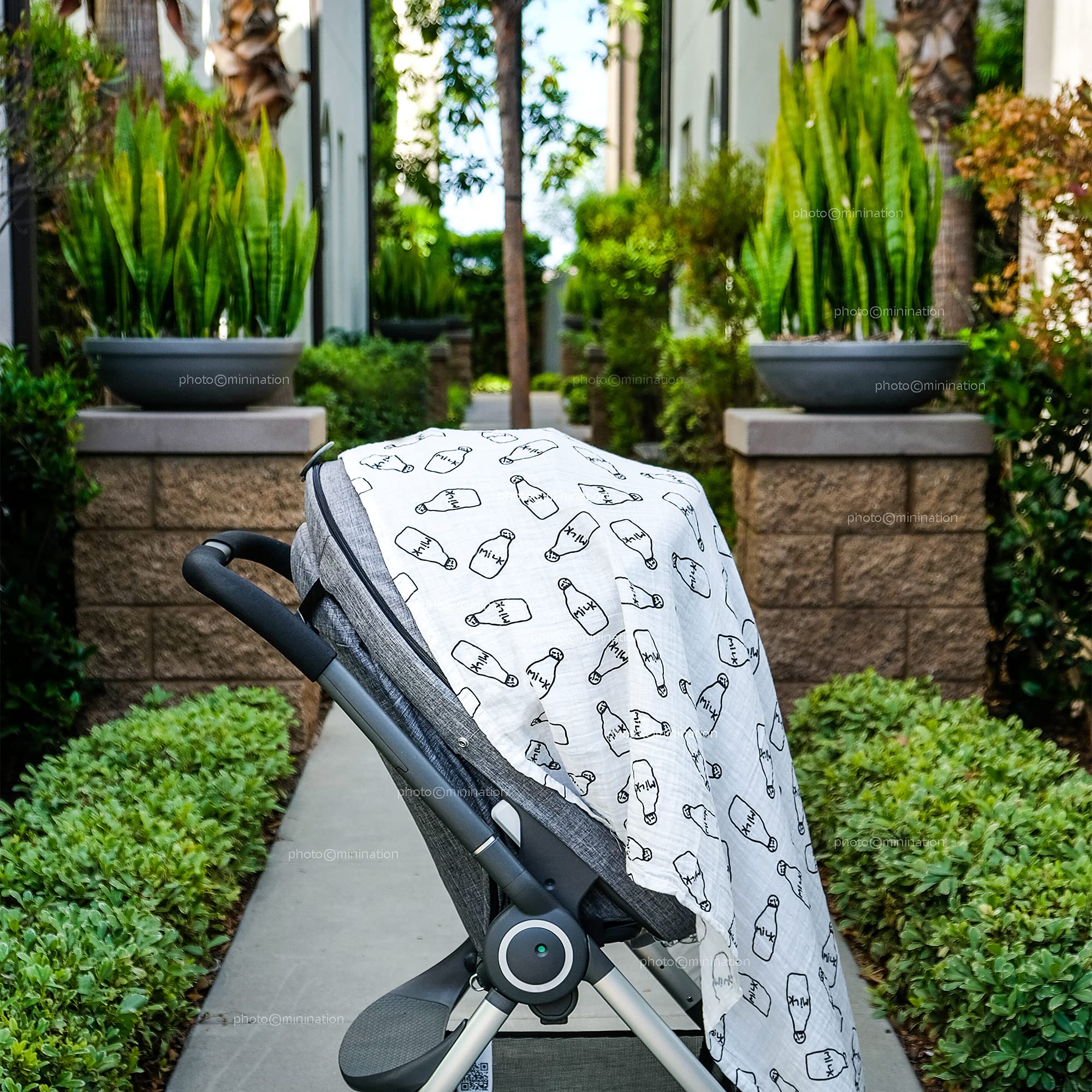 Minination milk print swaddle used as nursing cover for discreet feeding.