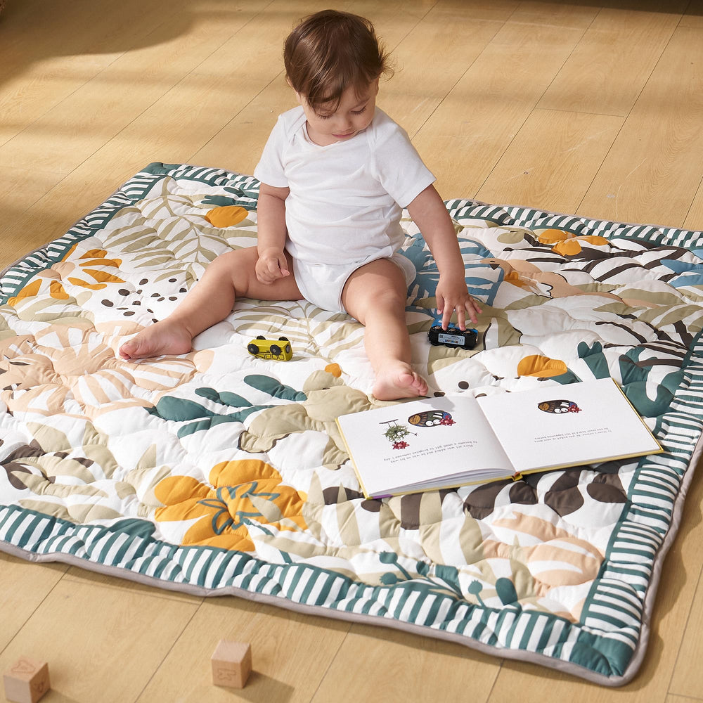 Momcozy Forest World mat with carrying strap for travel.