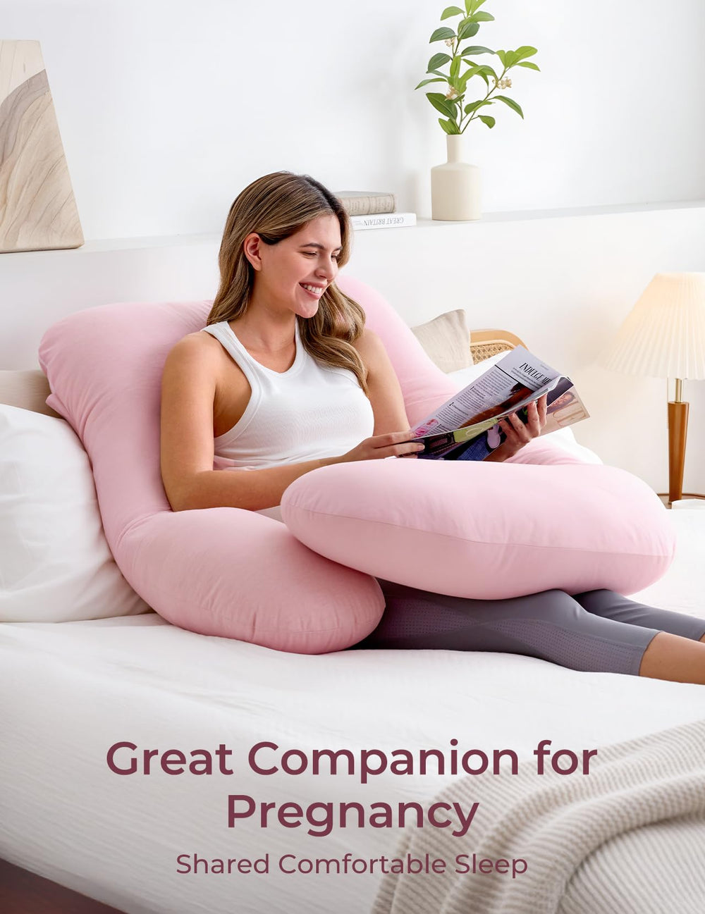 Momcozy pink belly-support pillow cradles belly to relieve pressure.