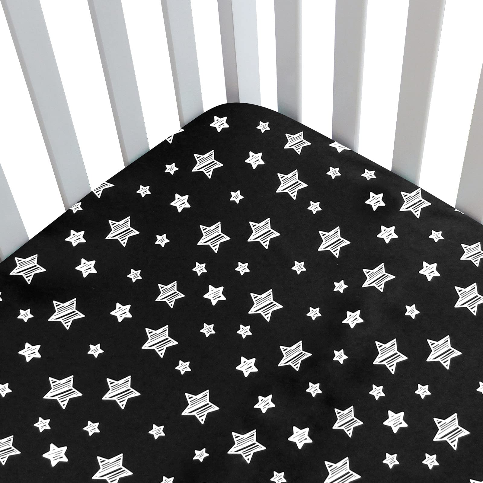 Moonsea Black Star crib sheet side view demonstrates snug fit for a standard crib