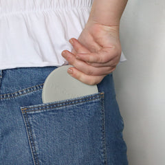 MOONTHLIES foldable container back pocket demonstrates tuck-away portability.