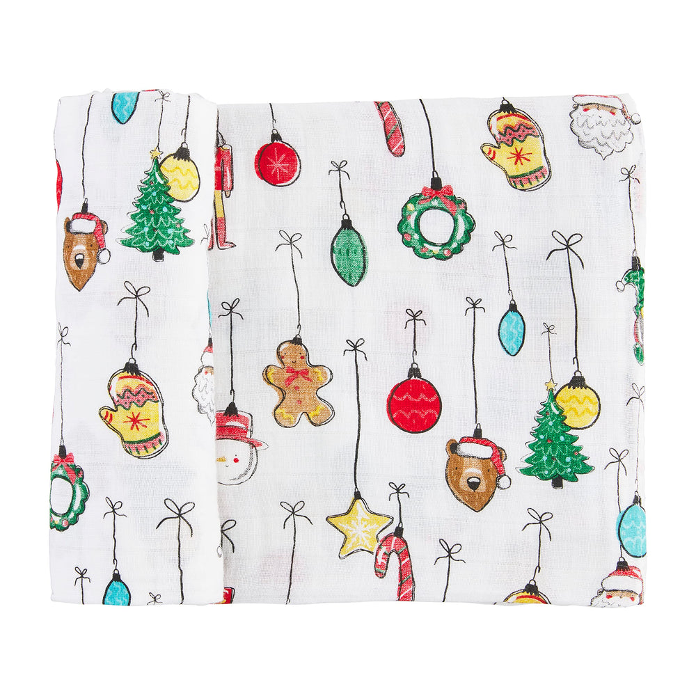 Mud Pie swaddle blanket featuring festive white ornaments; gentle on skin and machine washable.