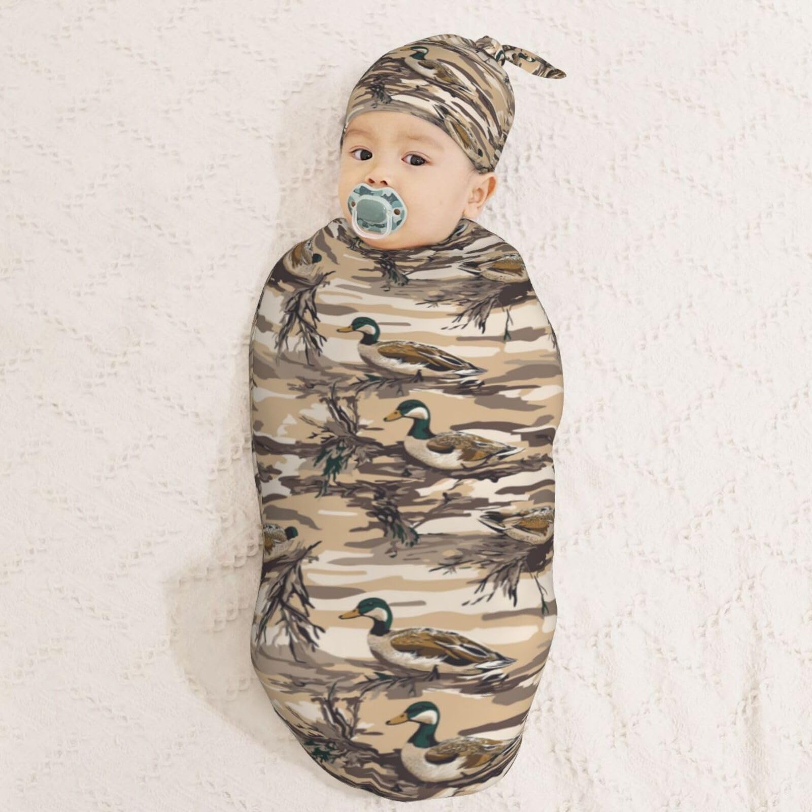Muishi duck camouflage swaddle on a sleeping baby suggesting soothing quiet time.