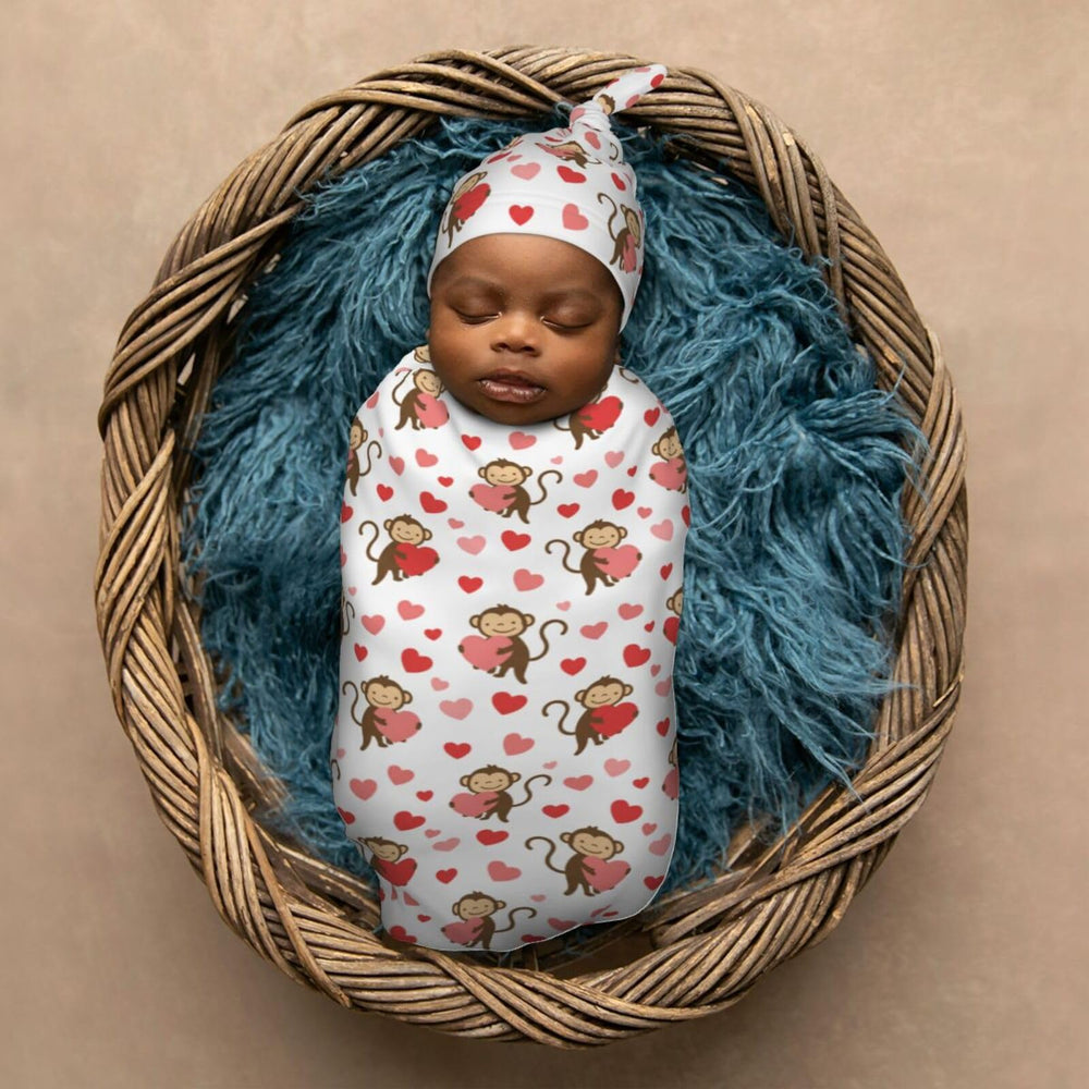 Baby swaddled in Muishi Monkey Love Heart blanket demonstrating cocoon wrap.