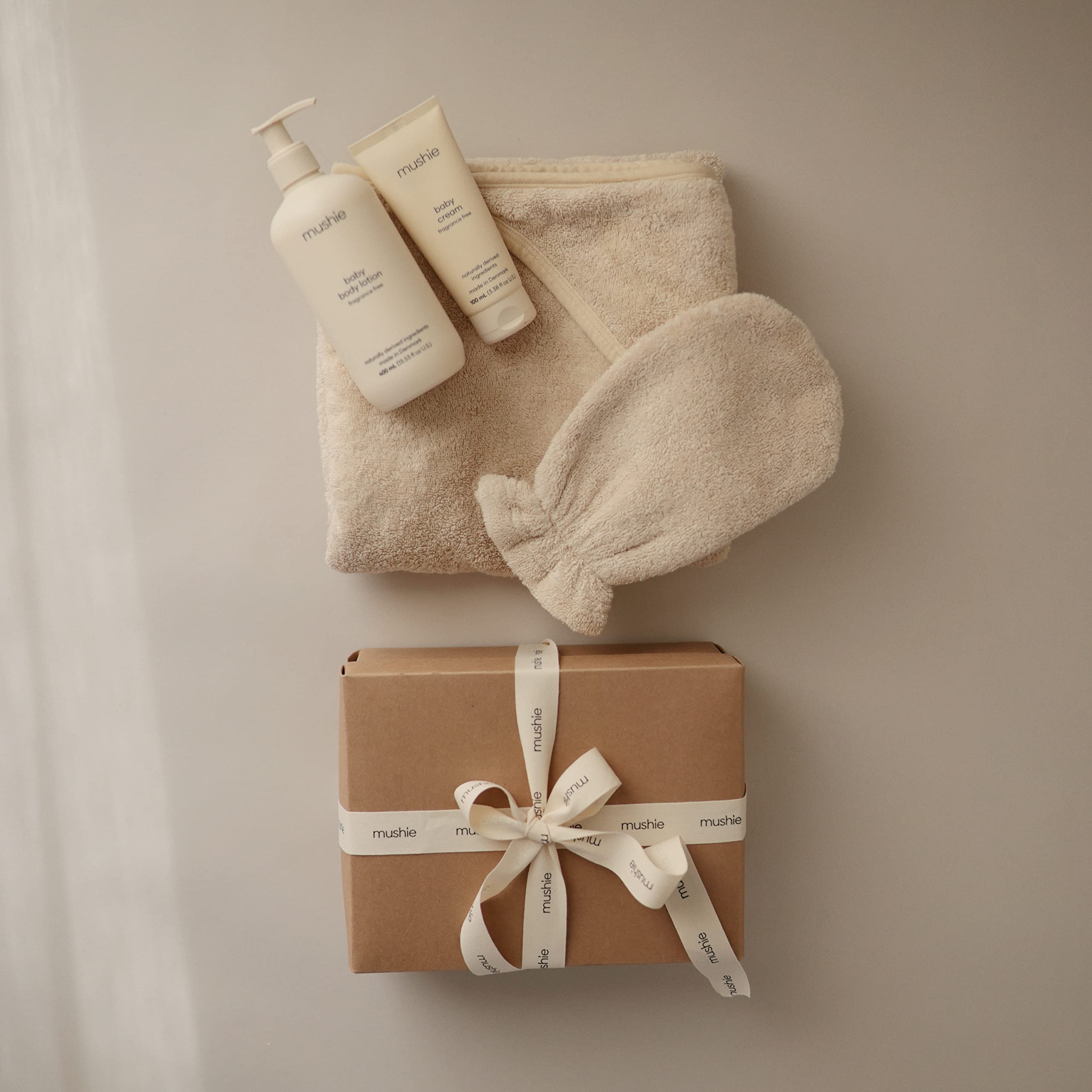 Mushie Baby Hooded Towel Pearl size reference for one-size comfort.