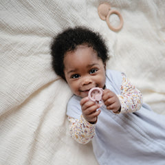Mushie blue wearable blanket on a baby in crib showing full-body coverage.