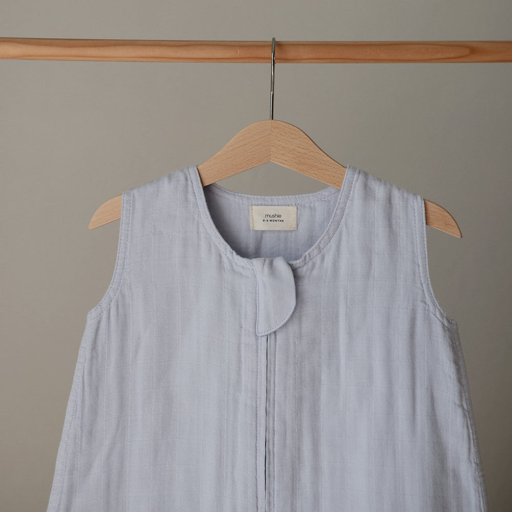 Mushie blue wearable blanket sleeveless-design on baby form promotes unrestricted leg movement.