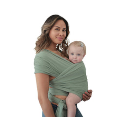 Mushie baby wrap in Roman Green worn comfortably on the shoulder for close bonding.