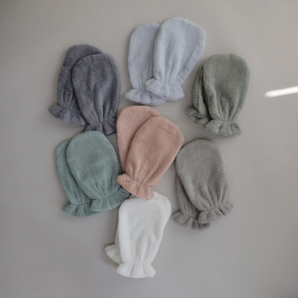Mushie elastic-cuff mitt on hand, secure fit during bath
