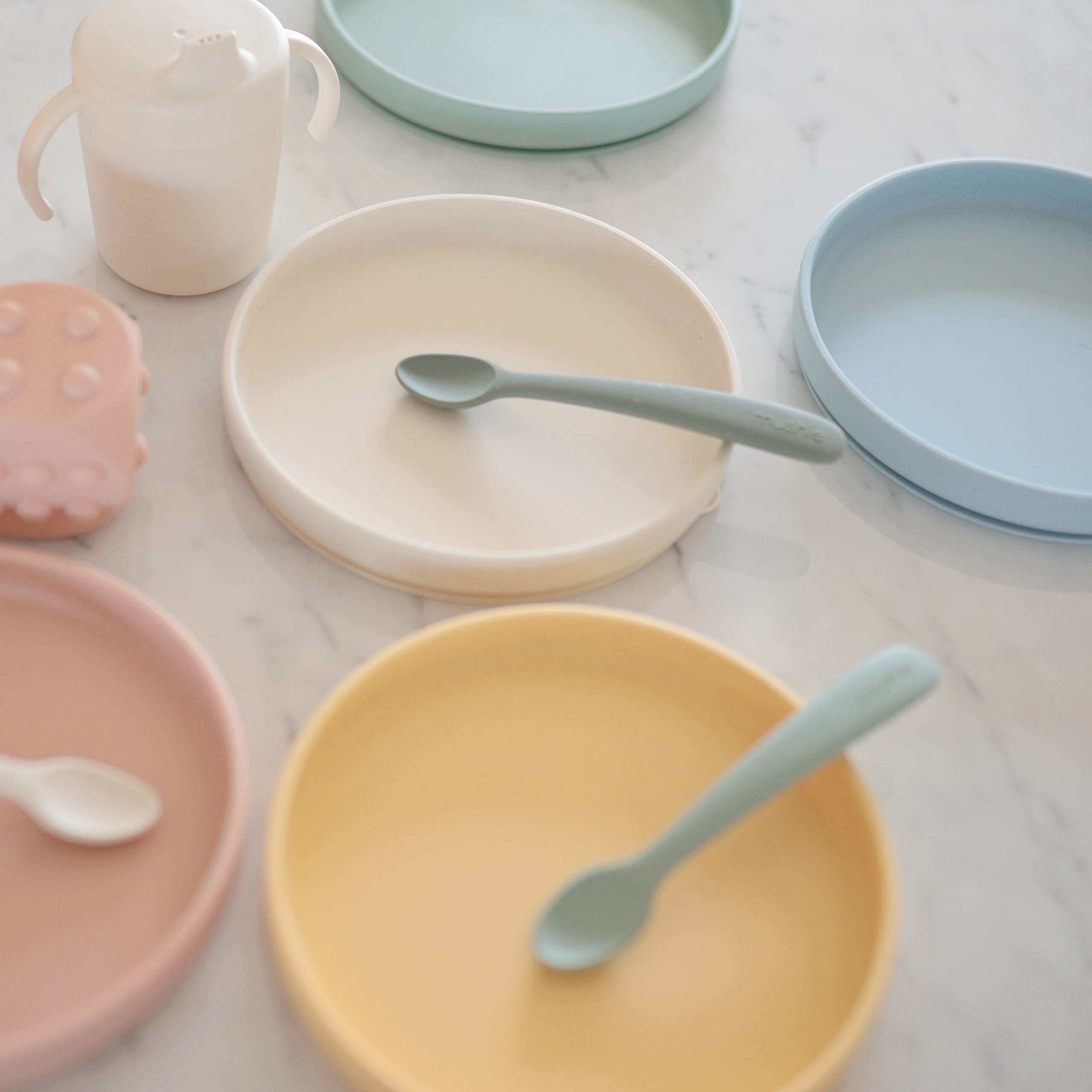 Mushie Classic Silicone Suction Plate stone mealtime scene with toddler self-feeding.