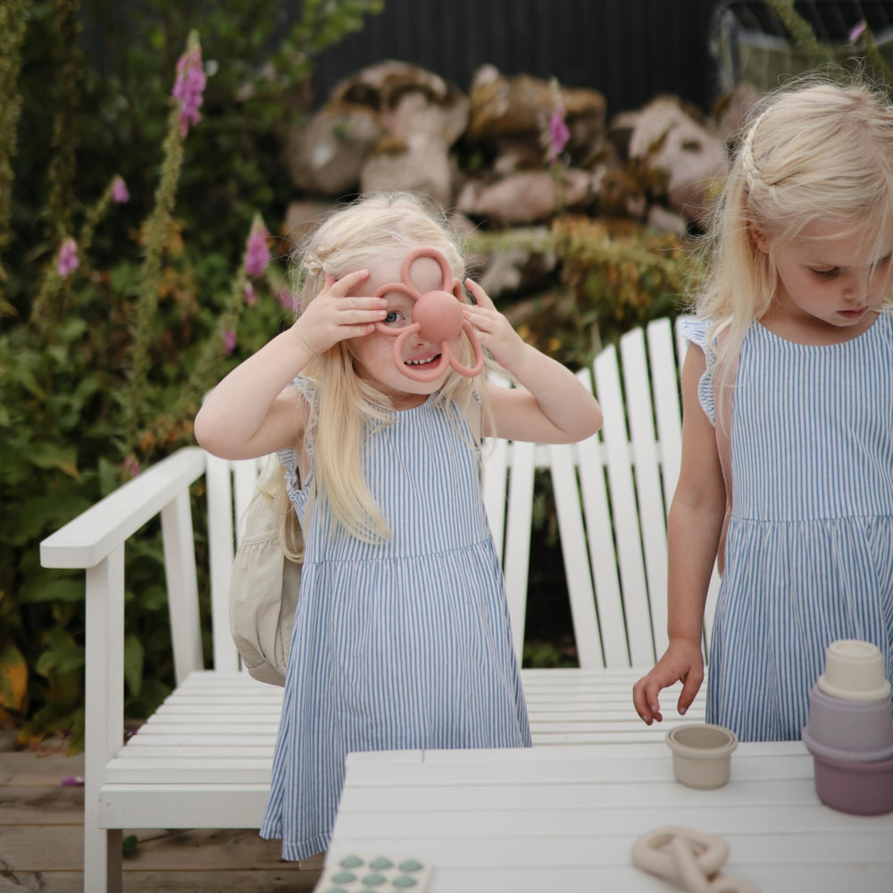 Mushie Daisy Rattle built-in rattle encourages auditory play.