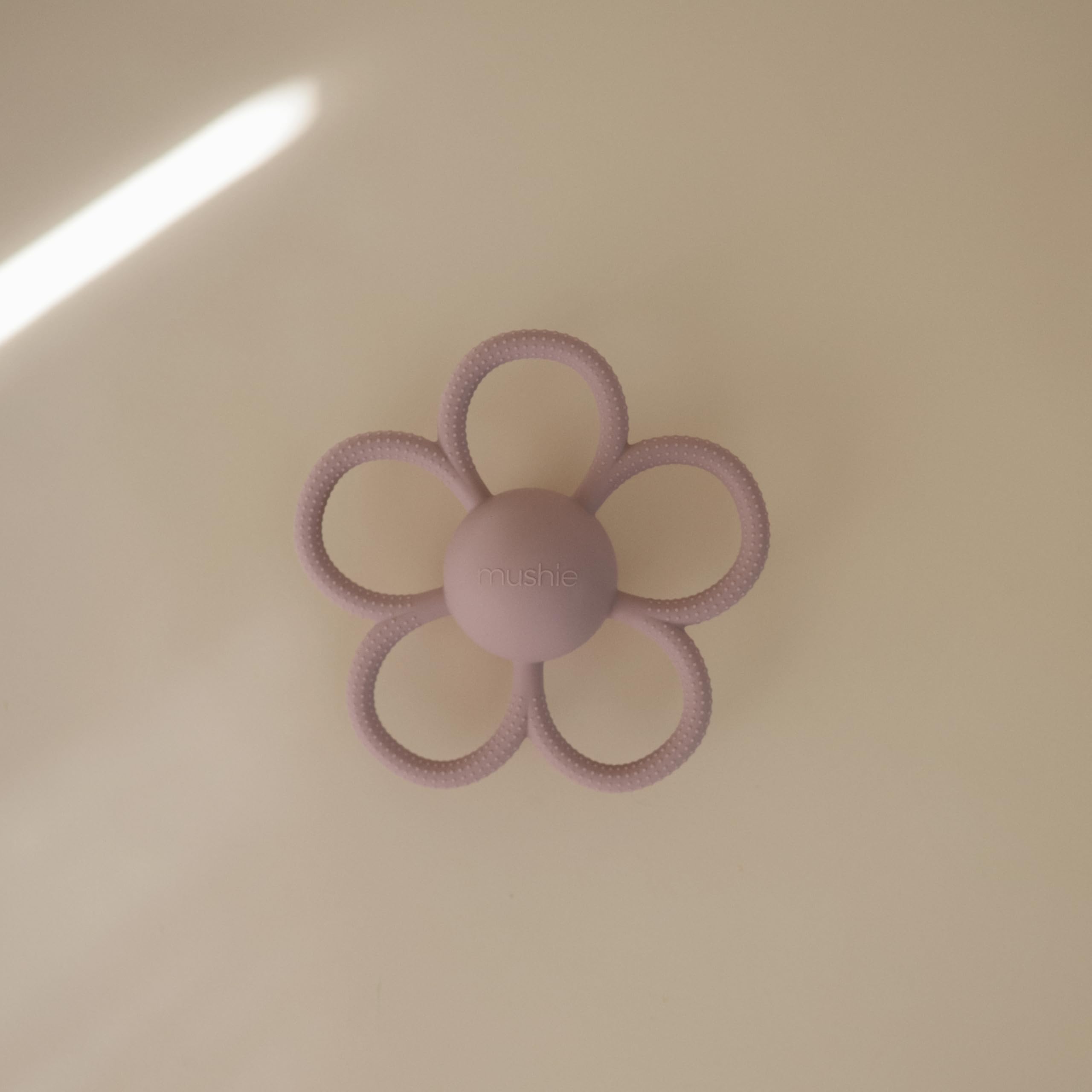 Close-up of Mushie Daisy rattle teether showing textured silicone surface.