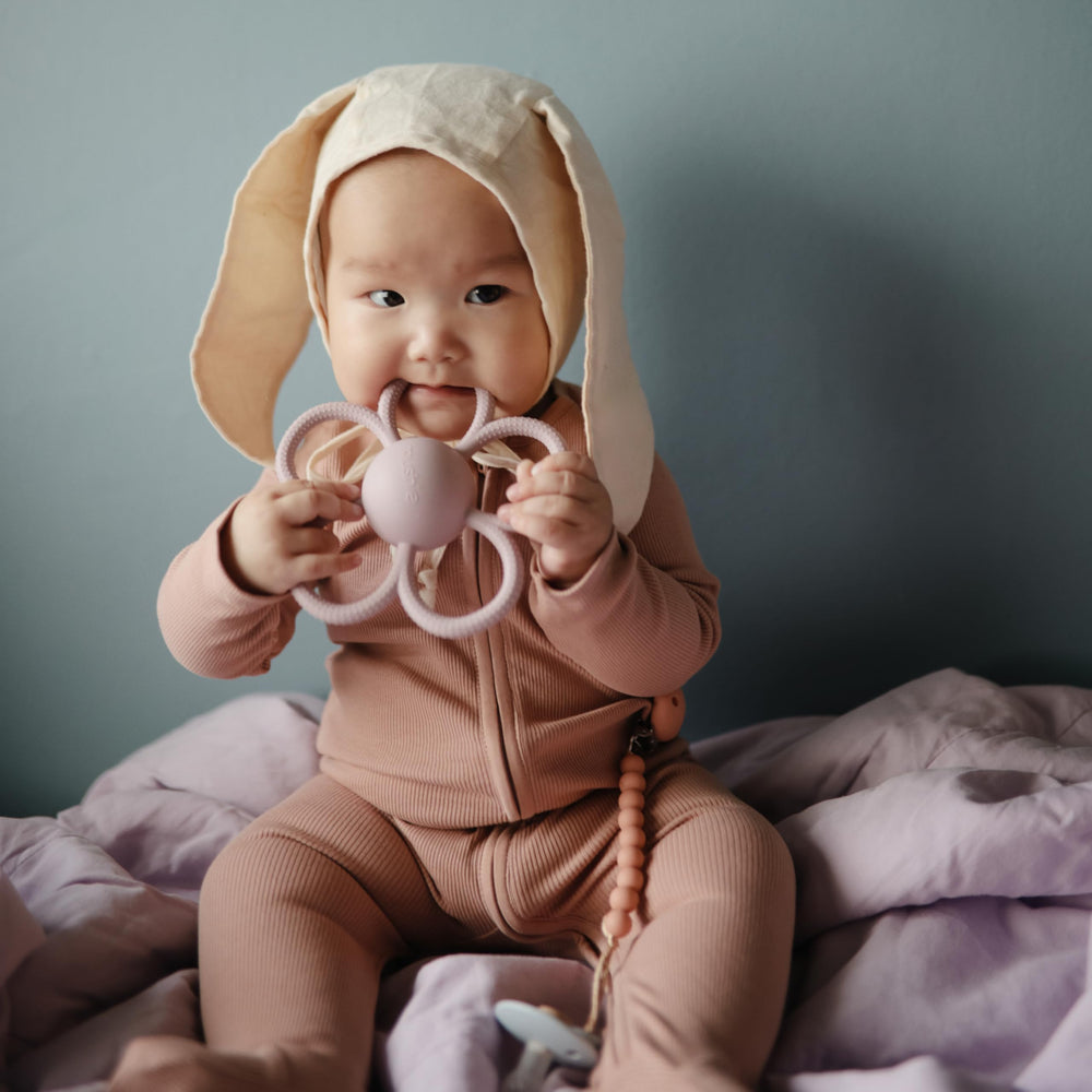 Daisy rattle teether texture massages gums during mouthing and exploration.