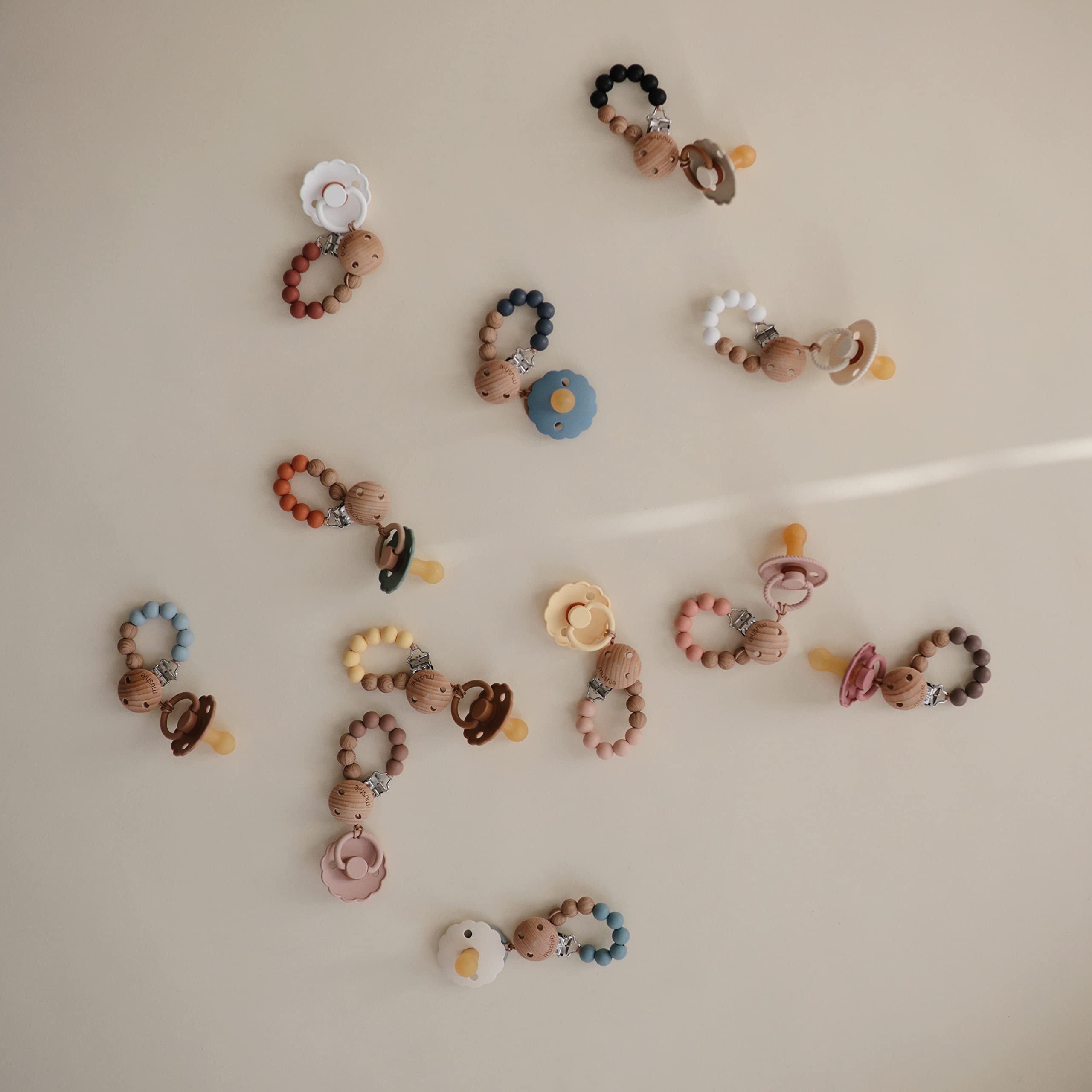 Mushie Eva clip in-use scenario helps keep pacifiers within reach during travels.