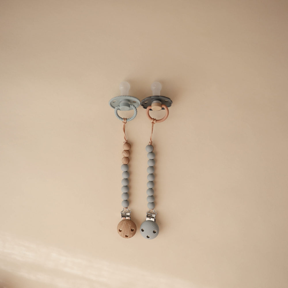 Mushie Eva clip silicone clasp keeps soothing items within easy reach.