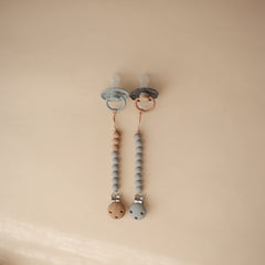 Mushie Eva clip silicone clasp keeps soothing items within easy reach.