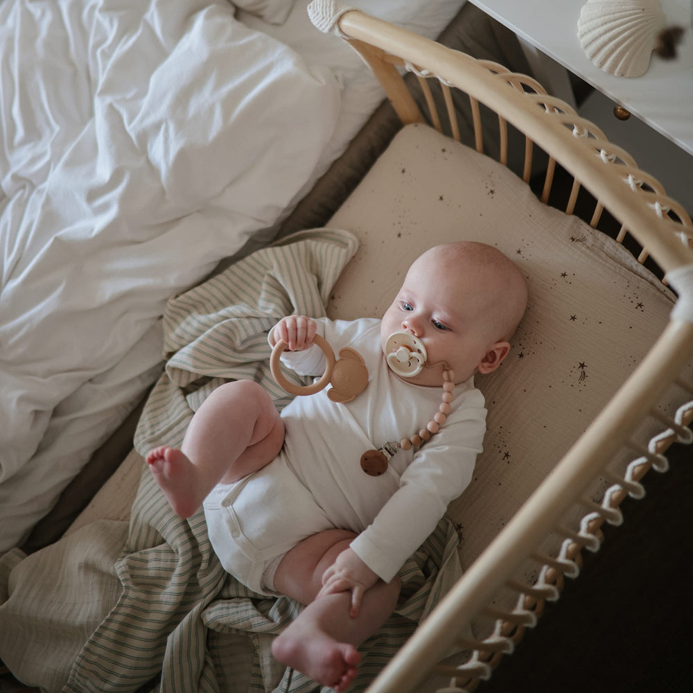 Mushie Eva pacifier clip eight-inch length for gentle reach.