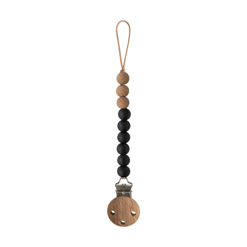 Mushie Eva silicone pacifier clip in black keeps pacifier within reach and tethers it safely.