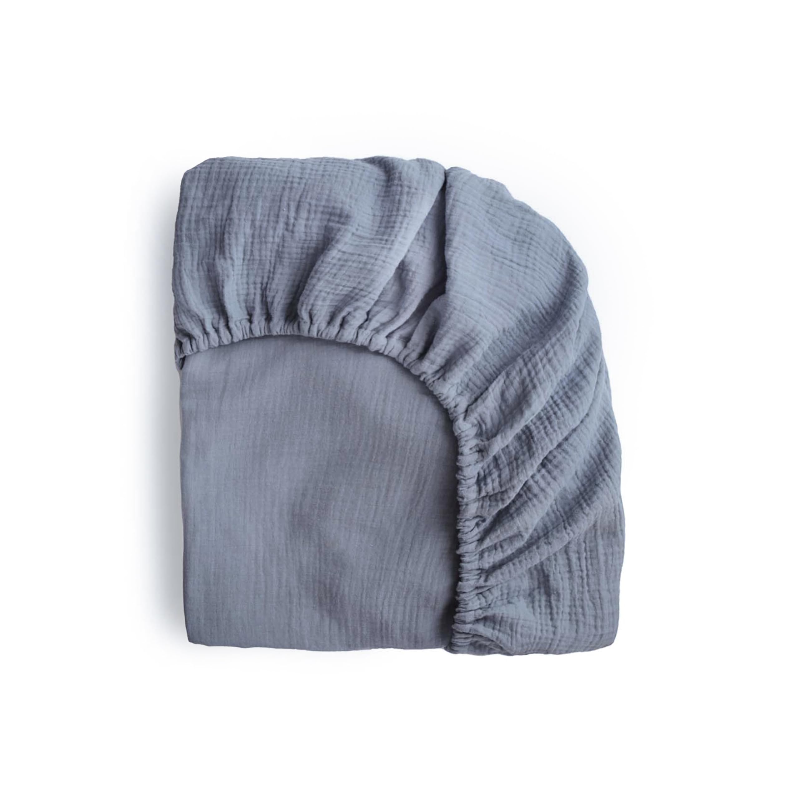 Mushie extra soft muslin mini sheet in Tradewinds folded for a snug night