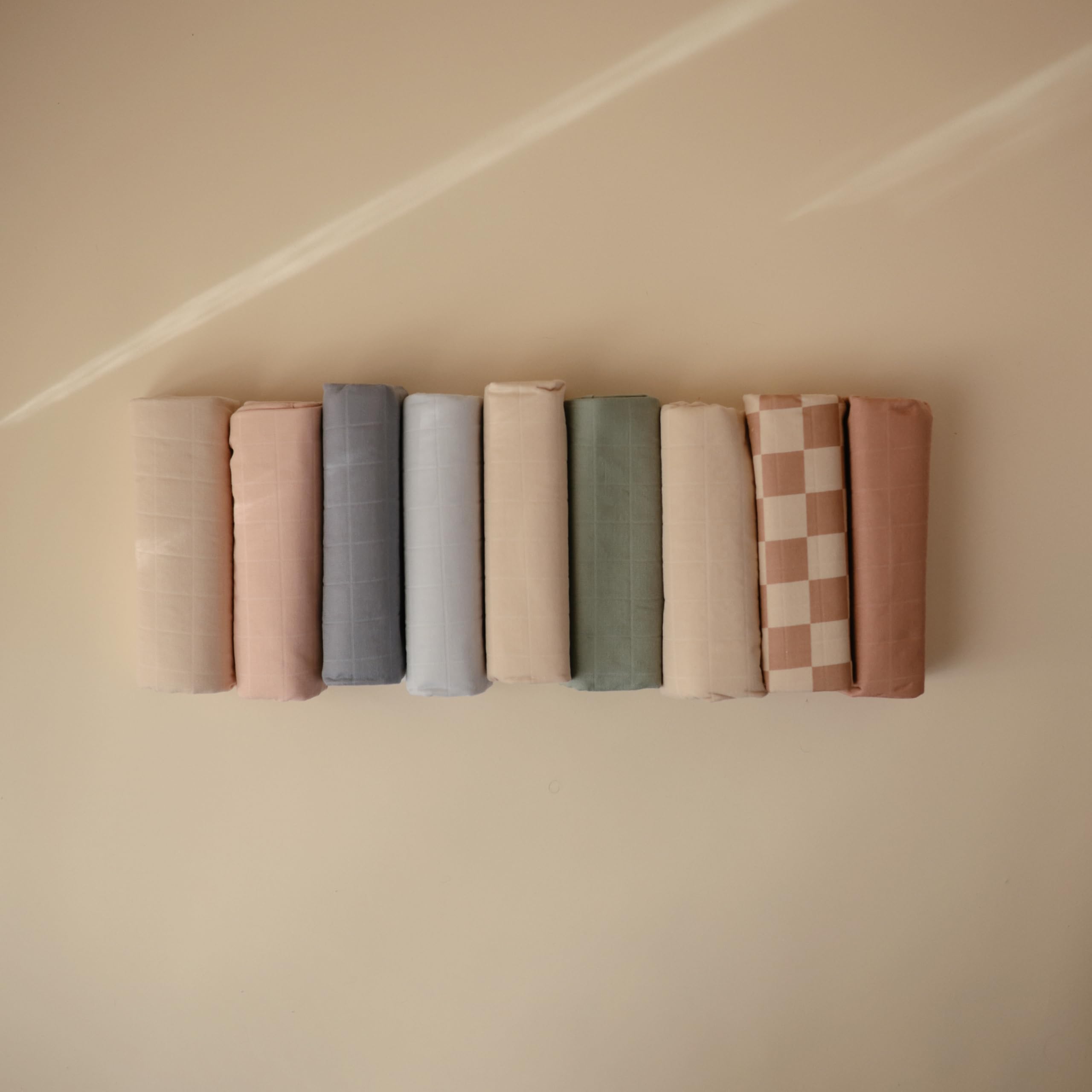 Mushie natural check design coordinates with nursery decor.