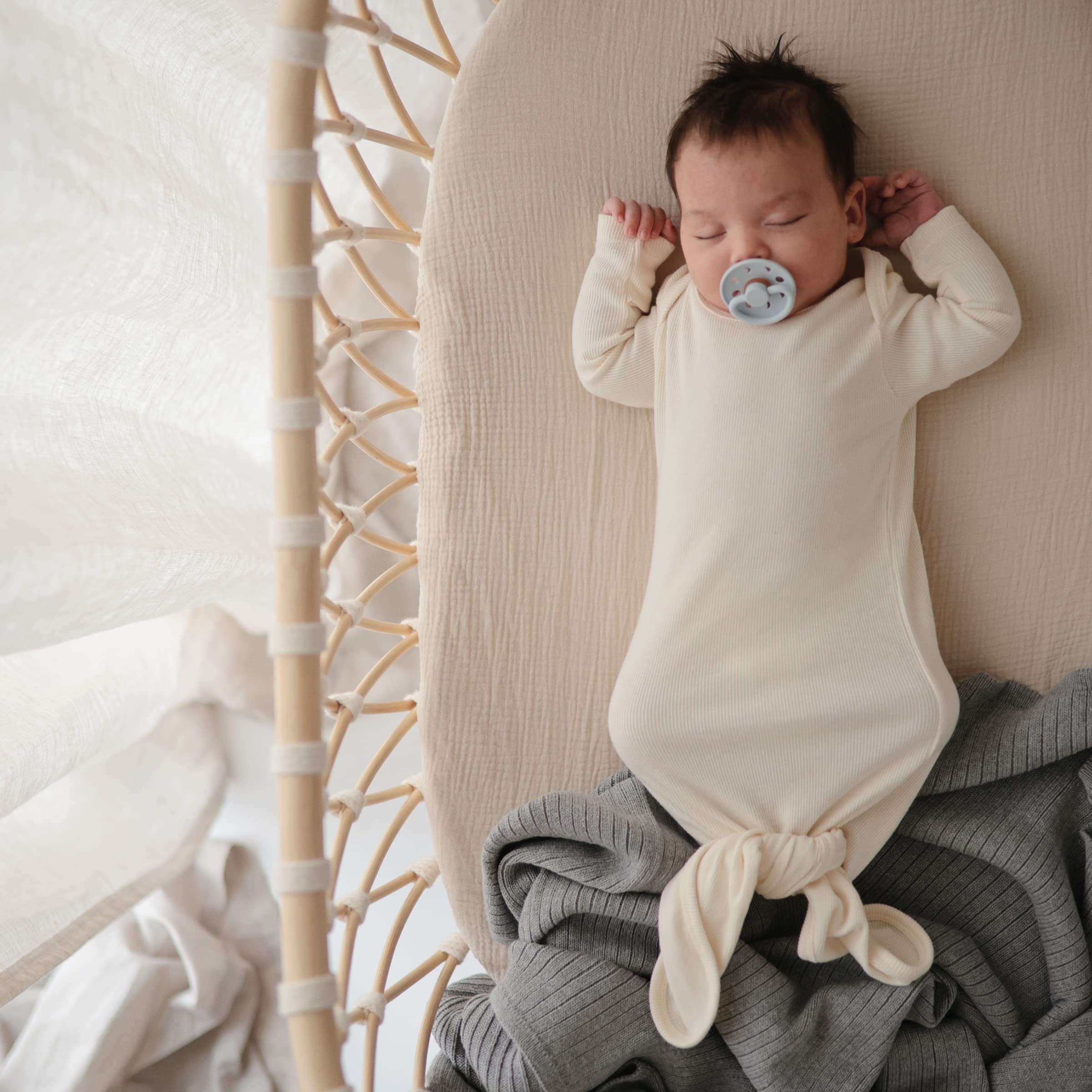 Mushie fitted mini crib sheet with full elastic edge for secure fit.