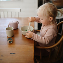 Mushie ivory flatware spoon featuring soft-grip handle.