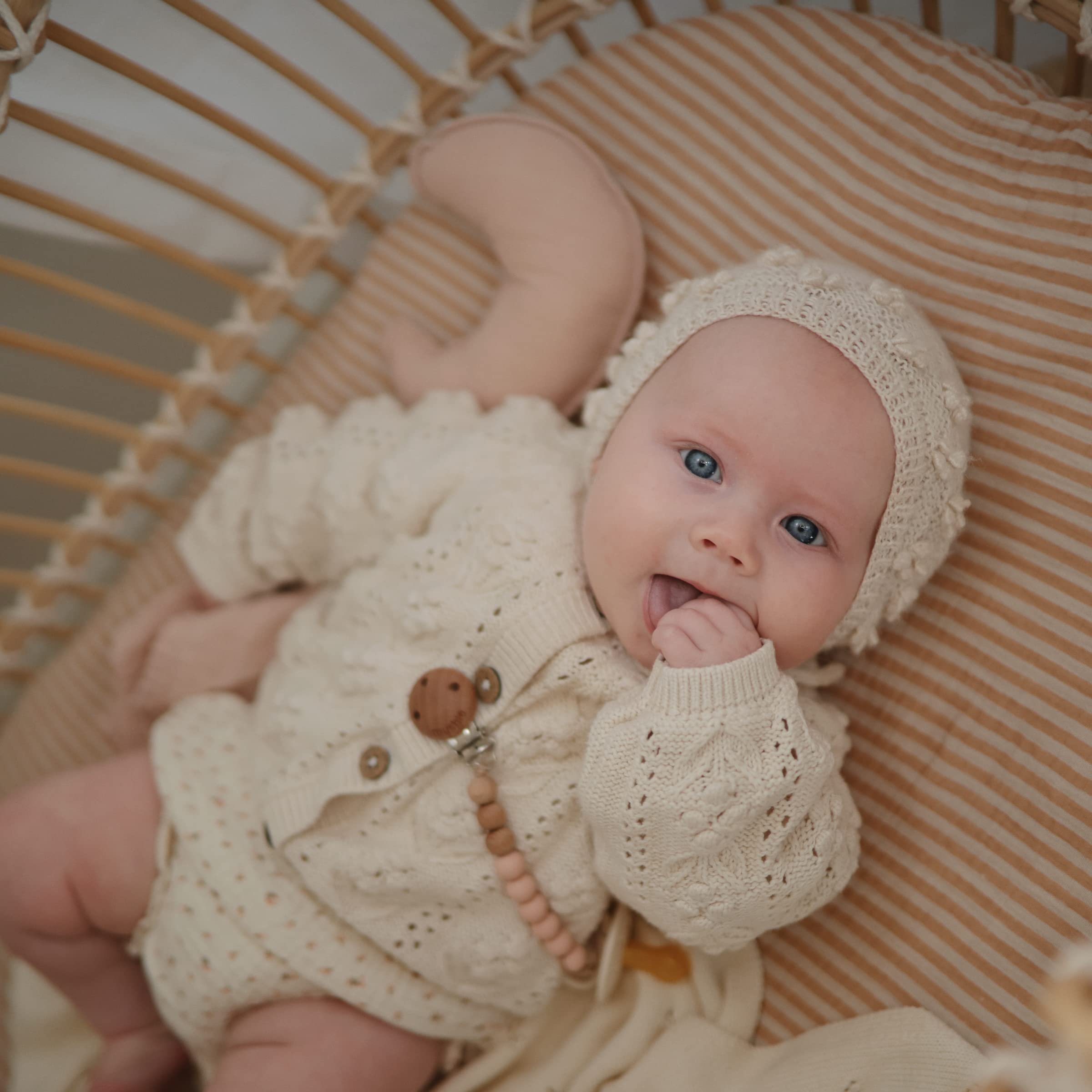Mushie fitted sheet with elastic edges shown on rectangular MINI crib for a secure fit.