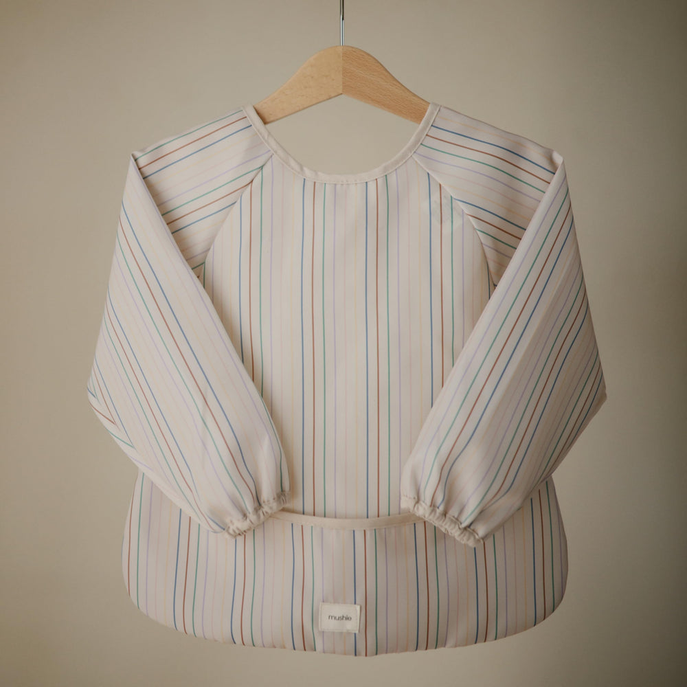 Mushie long sleeve bib pocket detail highlights food catch area