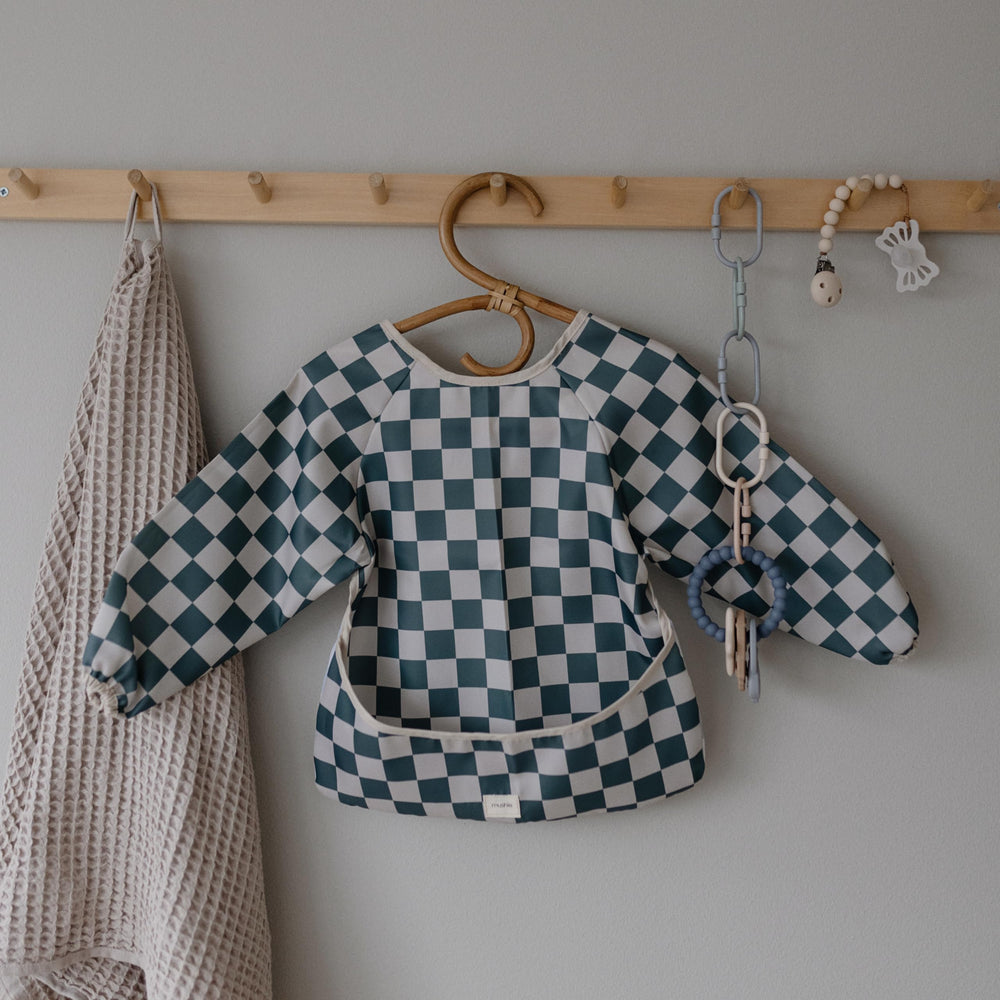 Mushie bib Olive Check laid flat to dry after washing